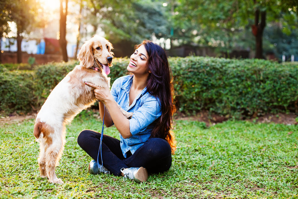 woman with her dog in a grassy yard